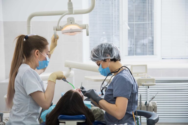 female-dental-assistant-working-with-dentist-curing-dental-cavity